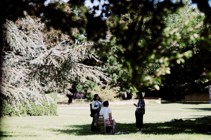 Three people standing on the grass on a summer's day at St Augustine's College of Theology.