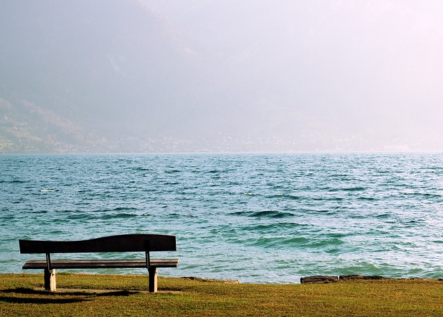 A bench on a hillside overlooking the sea.