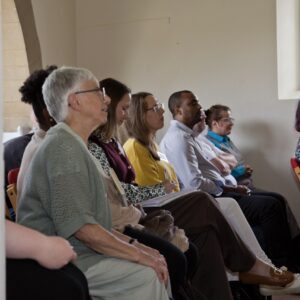 Six people sitting on chairs in a room listening to a talk.
