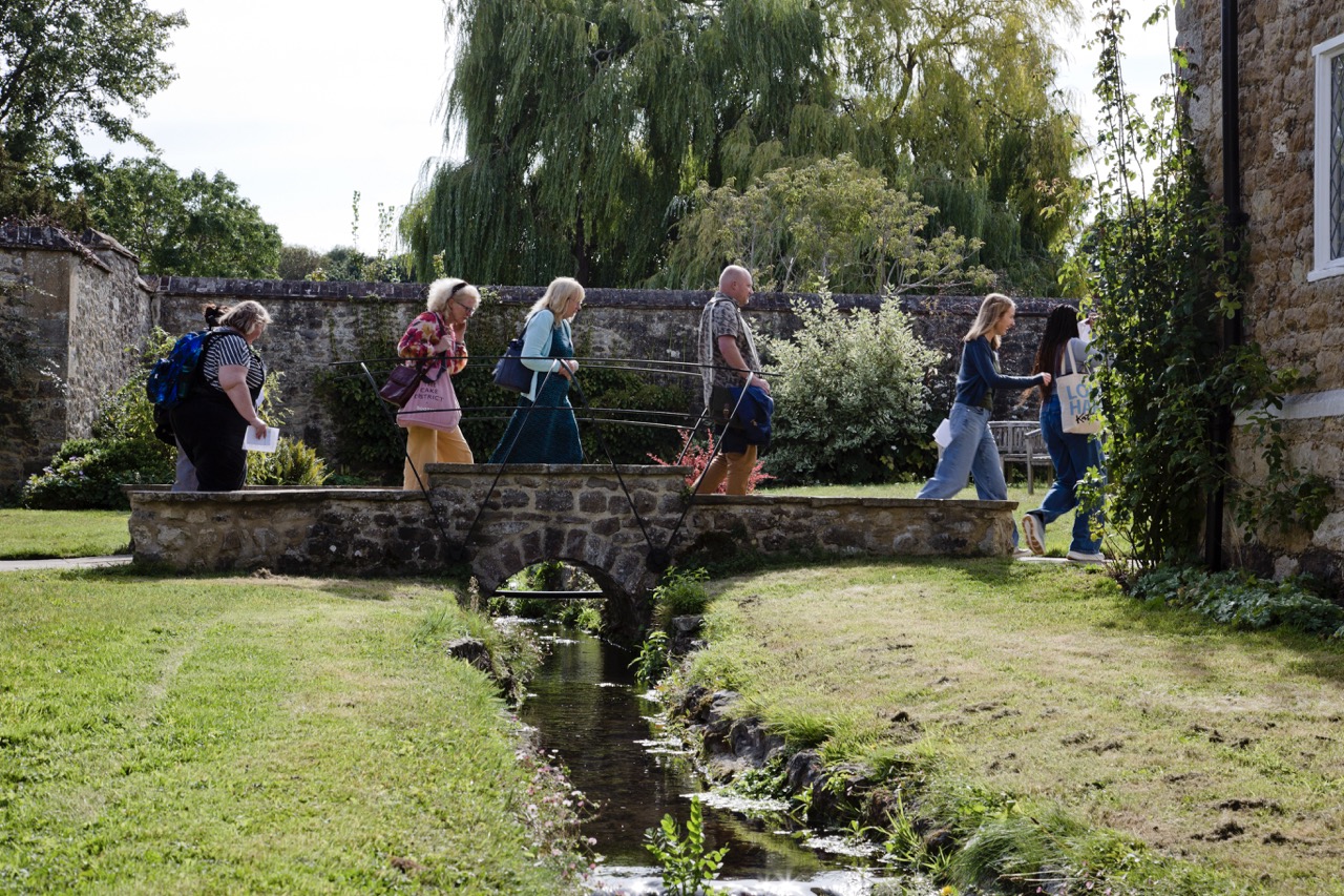 Walking over the bridge at West Malling Six people walking over a small brick bridge on the grounds of West Malling campus in Kent.
