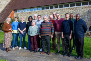 Lay Ministry students - a group of people, men and women, standing together on the grass in a group outside a stone building.